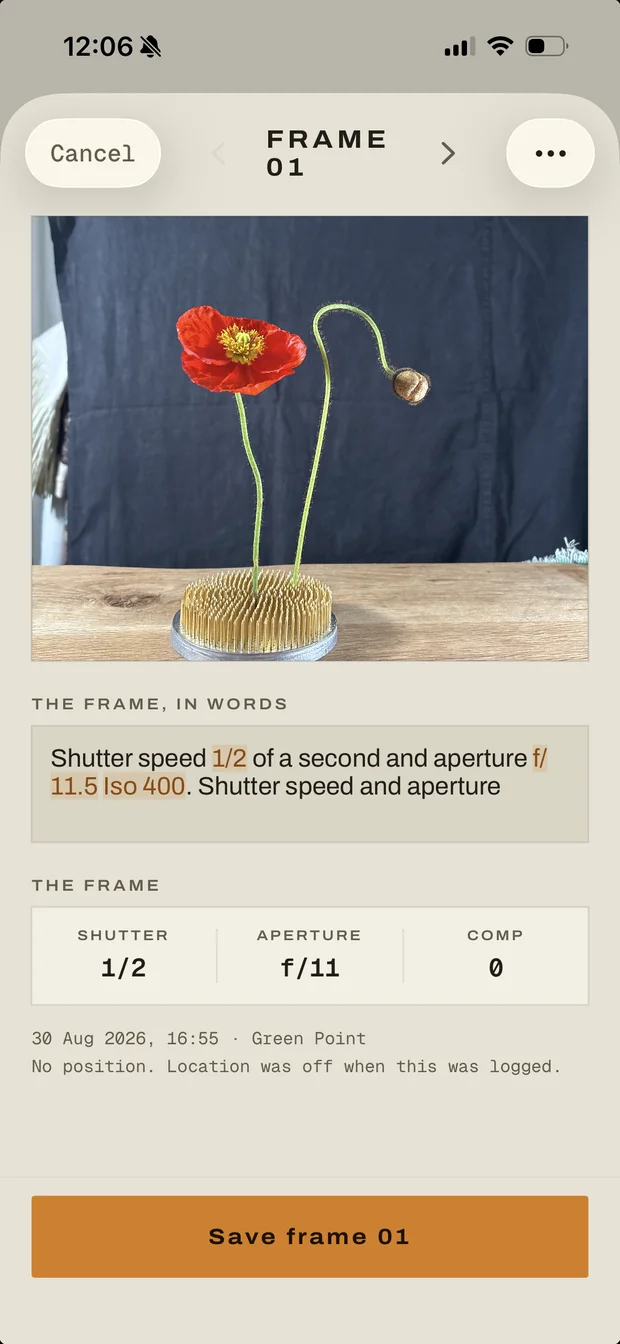 Frame 01 on the phone: the poppy photographed in the gate, the spoken sentence with 1/2, f/11.5 and ISO 400 marked in it, and the reading below: 1/2 at f/11.